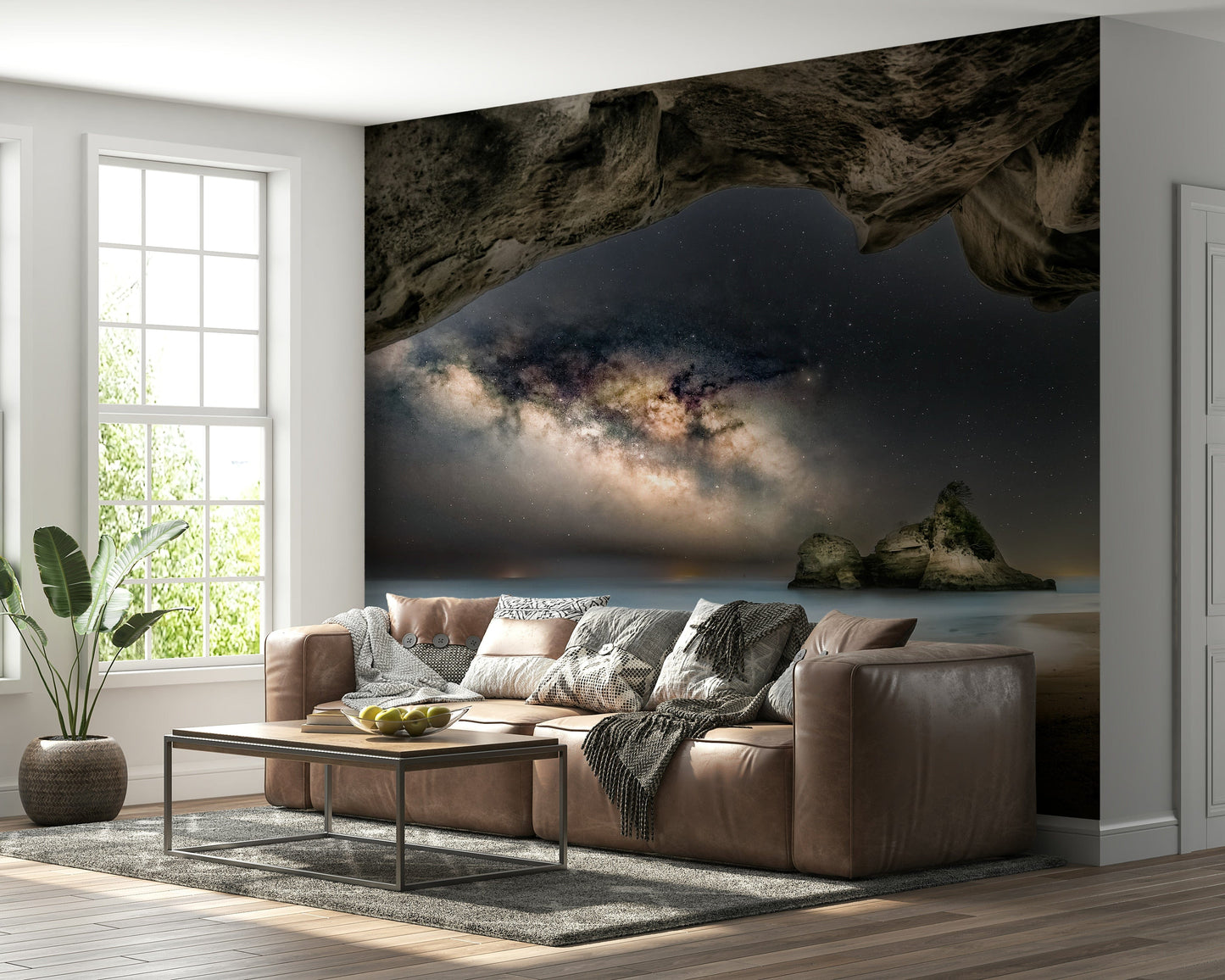 Cave Portal to Starlight wallpaper mural of the Milky Way in a cave behind a brown leather sofa in a living room
