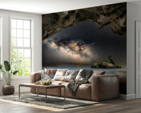 Cave Portal to Starlight wallpaper mural of the Milky Way in a cave behind a brown leather sofa in a living room