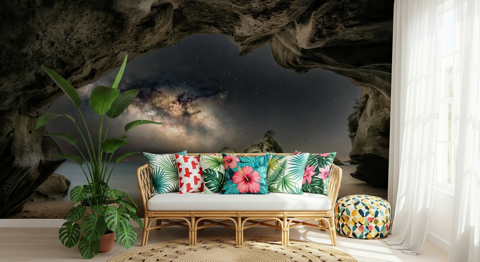 Cave Portal to Starlight wallpaper mural of the Milky Way in a dark cave behind a rattan sofa in a tropical living room
