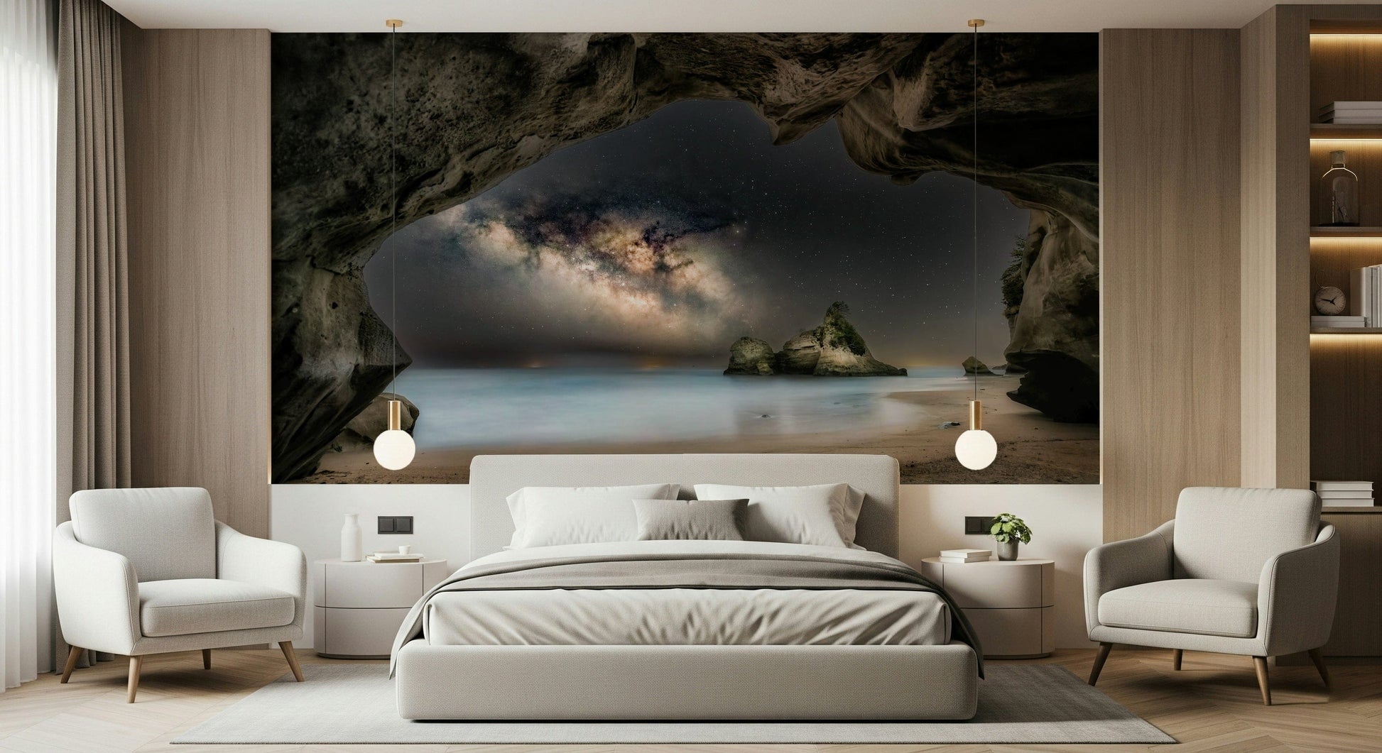 Cave Portal to Starlight wallpaper mural of the Milky Way in a sea cave above a gray bed and armchairs in a bedroom