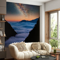 Nature-inspired mural with soft cloud wallpaper layers above rugged mountains and pale sky