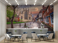 Features a historic old town scene with a cobbled street leading towards a grand, Gothic-style cathedral or large church.
