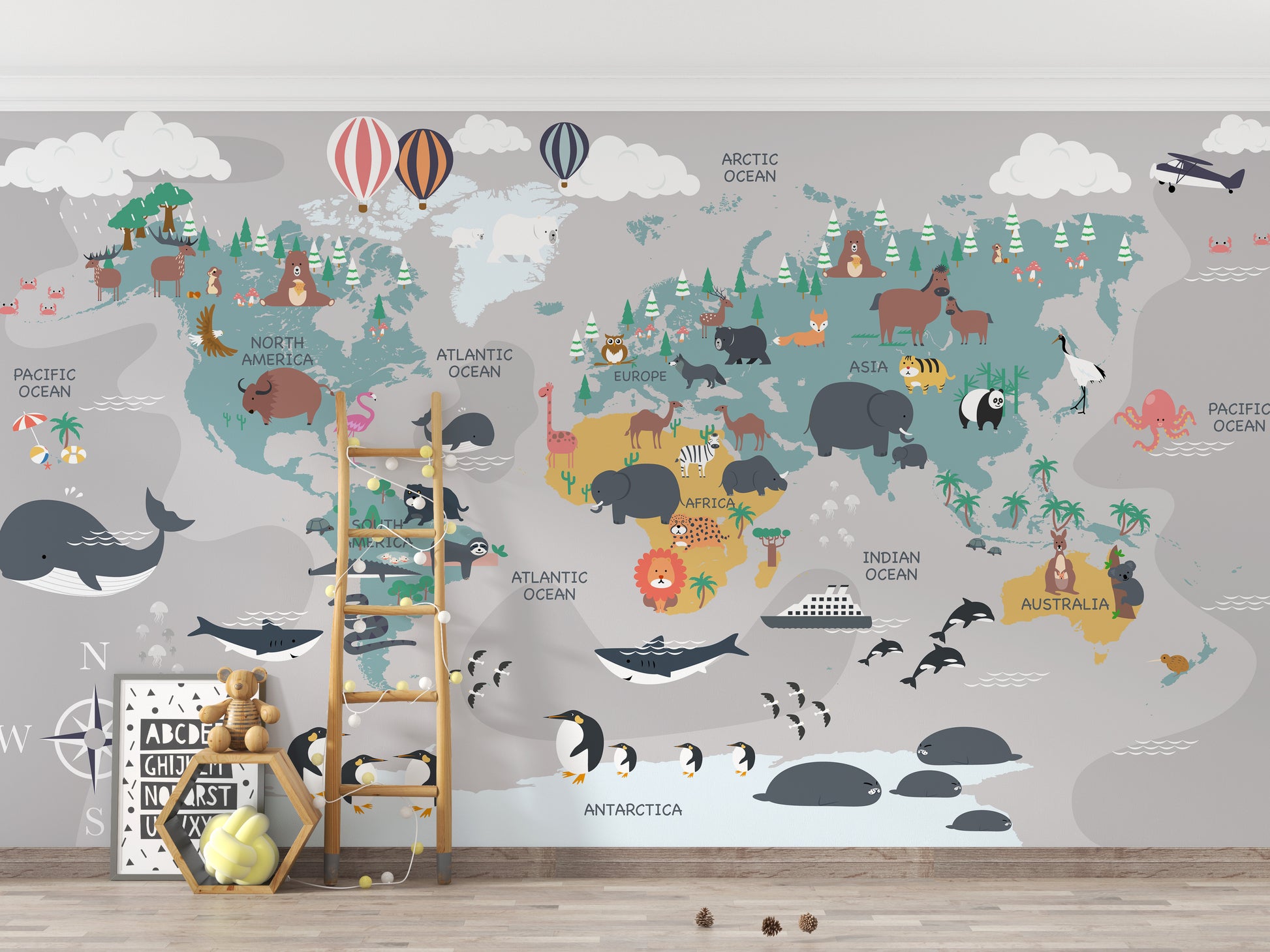 Children's World Map wallpaper with whales and penguins behind a wood ladder and teddy bear in a kids room