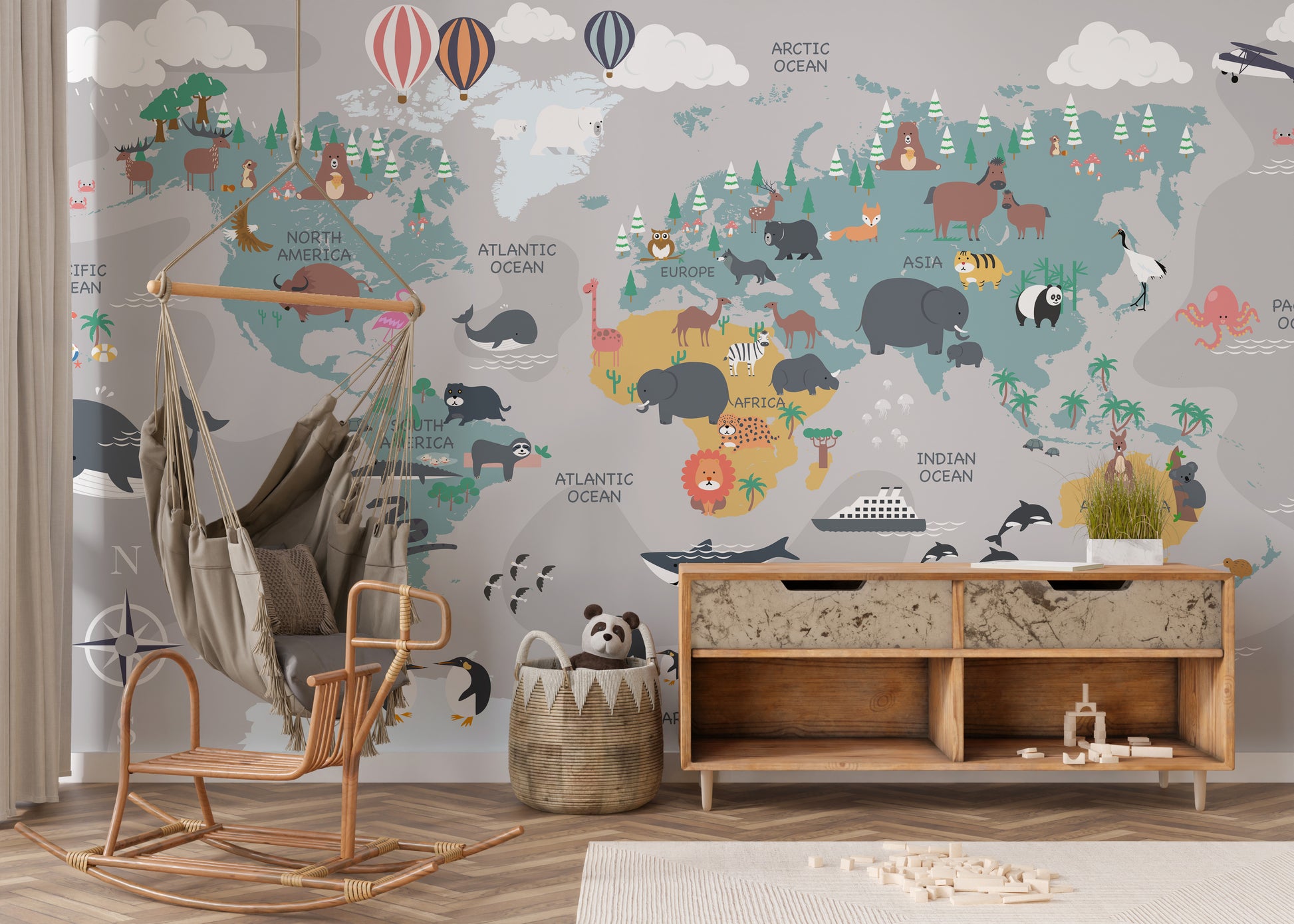 Children's World Map wallpaper with cartoon animals in blue and grey behind a rattan swing chair and wood console in a kids room