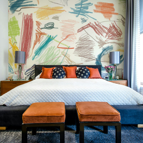 Cianfrusaglia V2 wallpaper mural of colorful crayon scribbles above a black bed with orange velvet stools