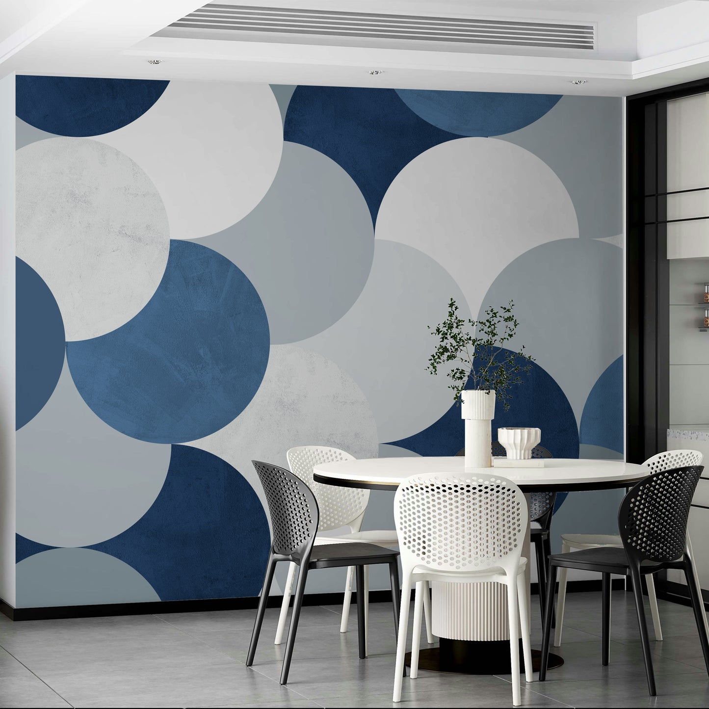 Circle Abstract wallpaper mural of navy geometric circles behind a white round table and black and white chairs