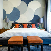 Circle Abstract wallpaper mural with blue and white circles above a black bed dressed with orange velvet stools