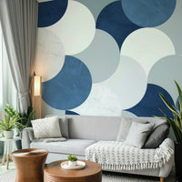 Circle Abstract wallpaper mural of slate blue half-circles behind a light gray sofa and wooden coffee tables