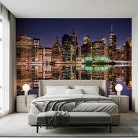 City night mural behind grey couch, skyline lights reflected on water