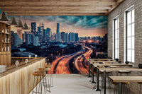 Cityscape Dawn wallpaper mural of a glowing city skyline along a wood bar counter with stools in a cafe