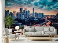 Cityscape Dawn wallpaper mural with Kuala Lumpur skyline and red highway trails behind a gray sofa in a bright living room