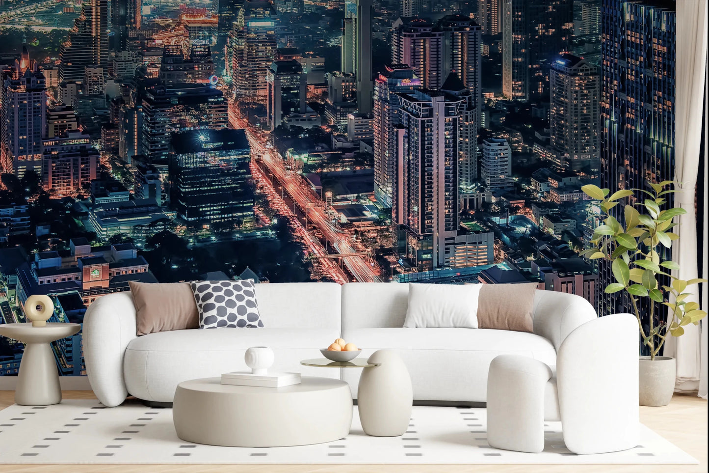 Cityscape Night wallpaper mural of a lit aerial skyline behind a white curved sofa and round ottomans