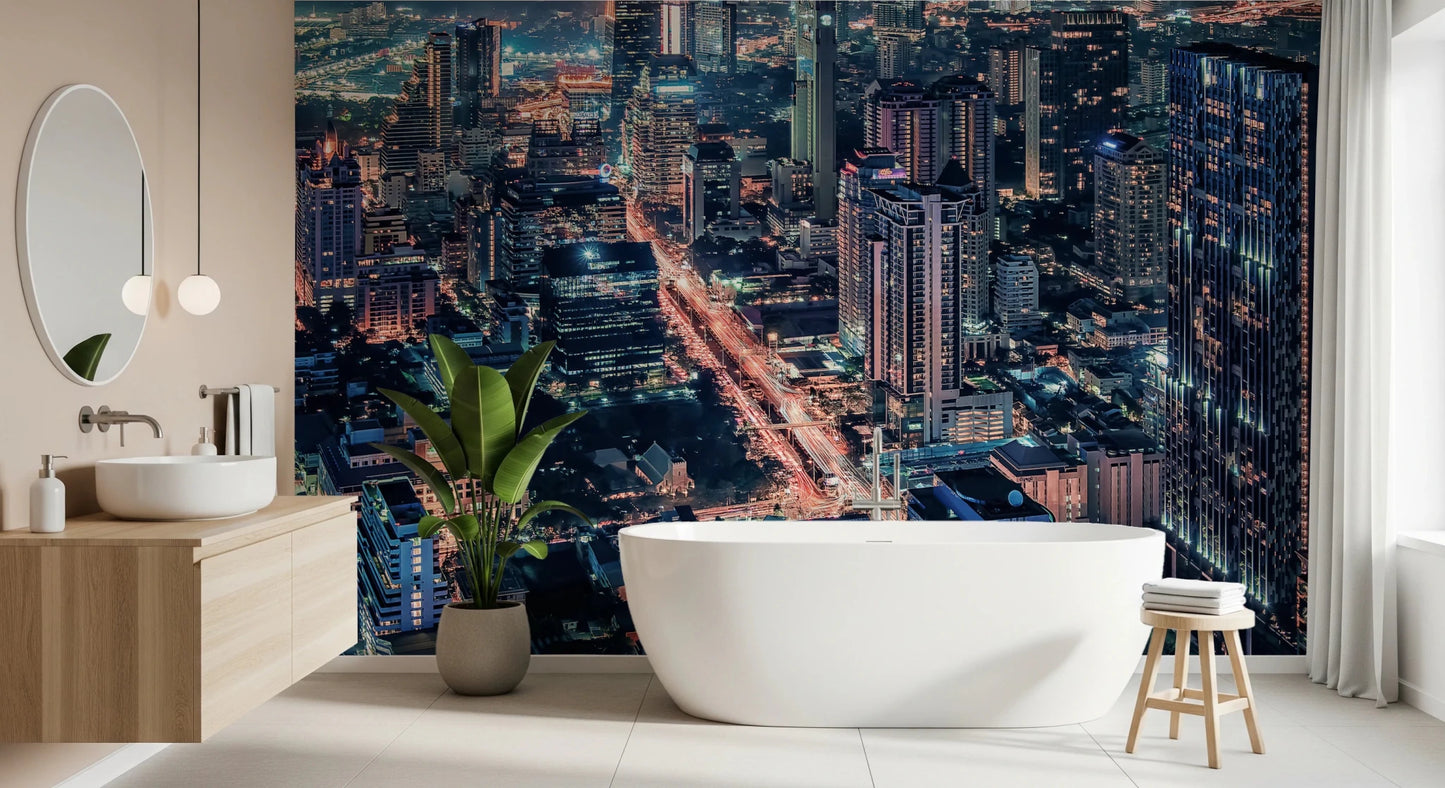 Cityscape Night wallpaper mural of an illuminated skyline in a bathroom with a freestanding white tub and plant