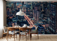 Cityscape Night wallpaper mural showing orange-lit city streets behind a wood dining table and chairs