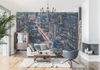 Cityscape Night wallpaper mural of skyscrapers and street lights behind a gray sofa and blue swivel chair