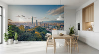 Cityscape Vista wallpaper mural of Taipei skyline over green hills behind a wood dining table and wishbone chairs