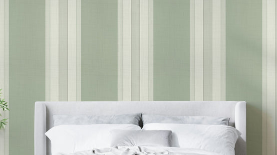 Classic Multiline Stripes Sage Green wallpaper behind a grey upholstered headboard in a soft bedroom
