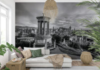 Classical City Charm wallpaper mural of monochrome Edinburgh behind a cream sofa with green cushions and rattan baskets