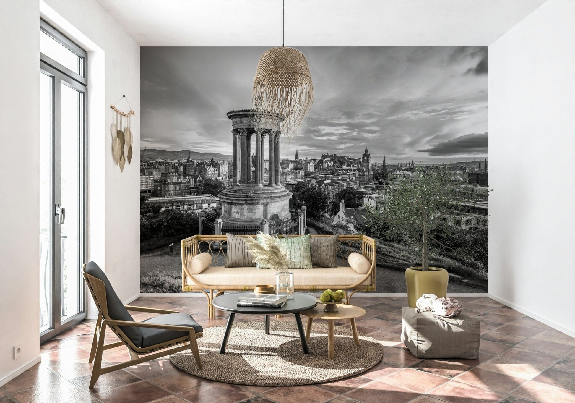 Classical City Charm wallpaper mural of grey Edinburgh cityscape behind a rattan sofa, woven pendant lamp and potted olive tree