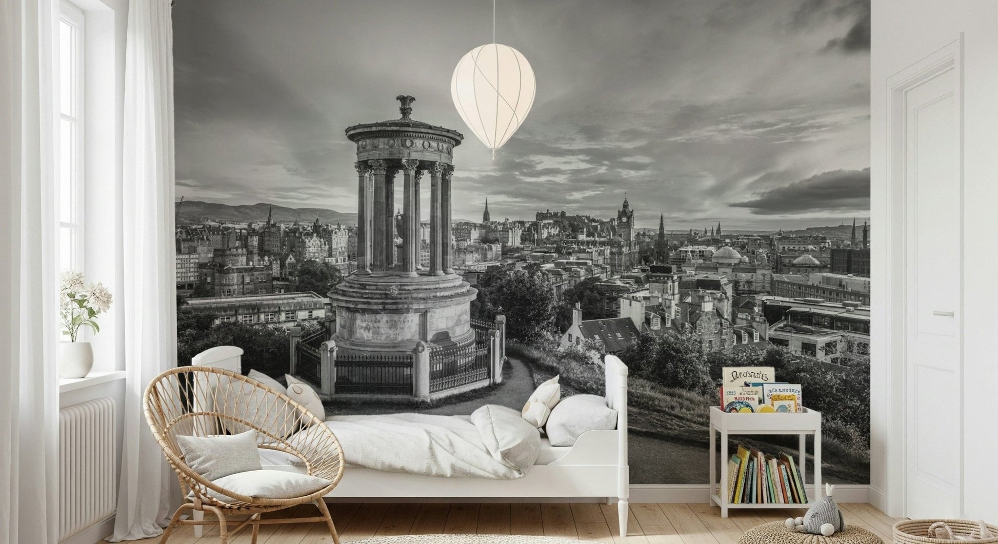 Classical City Charm wallpaper mural showing monochrome Edinburgh cityscape behind a white child's bed, rattan chair and bookshelf