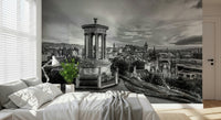 Classical City Charm wallpaper mural of Edinburgh monument behind a bedroom bed with white bedding, task lamp and potted plant