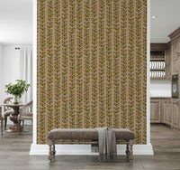 Colorful leaf motifs in orange and green forming playful vertical vine stripes on a beige wallpaper.