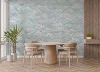 Clouds Baby Blue and White wallpaper mural of swirling teal clouds behind a round wooden dining table and beige chairs
