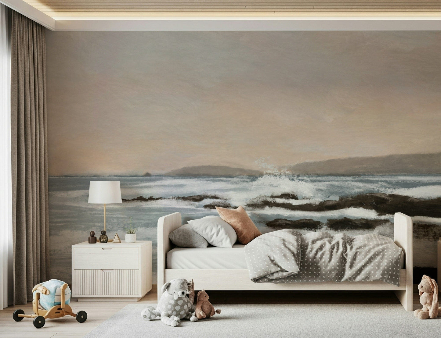Coastal Hues wallpaper mural of blue waves over rocks behind a white bed with a polka-dot duvet in a kids room