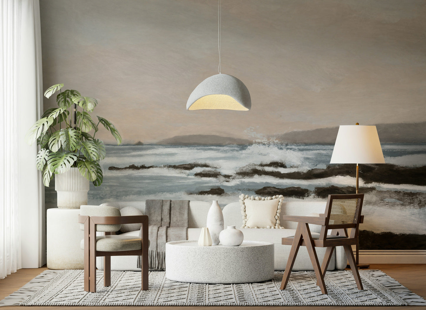 Coastal Hues wallpaper mural of a soft seascape behind a cream sofa and grey dome pendant in a living room