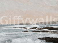 Coastal Hues wallpaper mural shown close up, pale blue waves breaking over dark rocks below a soft beige sky