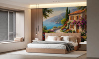 Coastal Cottage Bloom wallpaper mural of a coastal villa and blue bay in a bedroom with tan upholstered bed