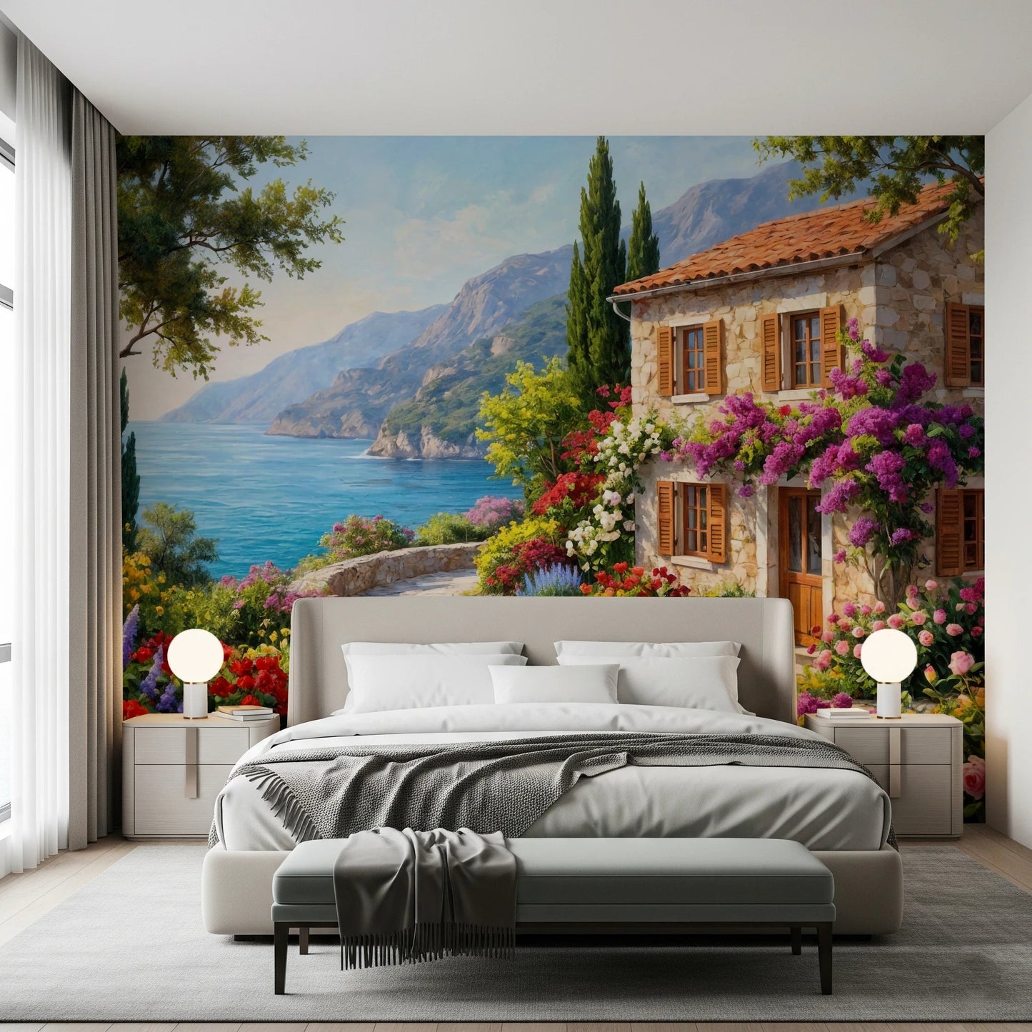 Coastal Cottage Bloom wallpaper mural of a seaside villa in a bedroom with grey bed and globe nightstand lamps