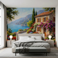Coastal Cottage Bloom wallpaper mural of a seaside villa in a bedroom with grey bed and globe nightstand lamps