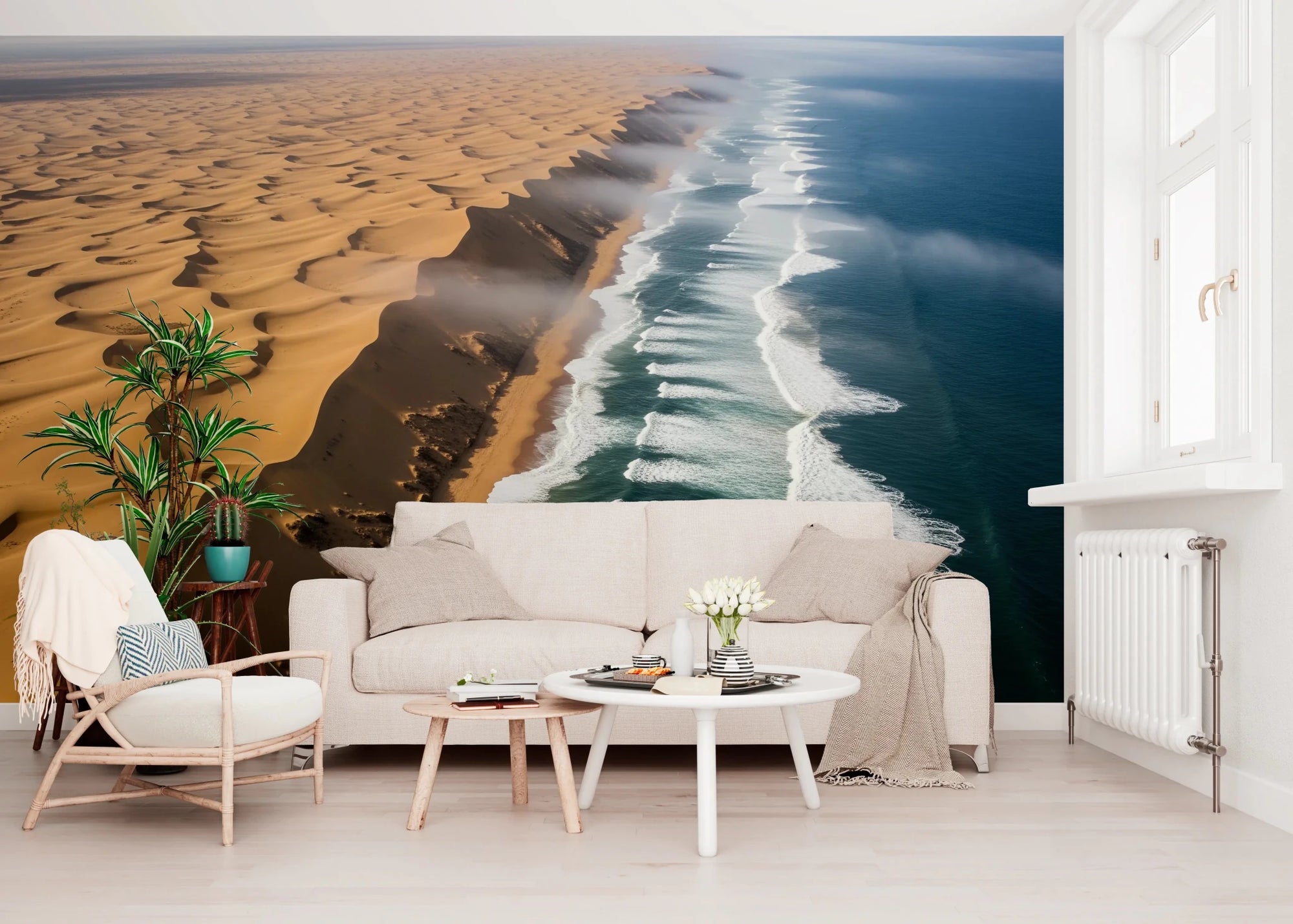 Coastal Dunescape wall mural of golden dunes meeting ocean waves behind a beige sofa in a living room
