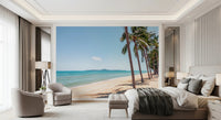 Coastal Palm Serenity wallpaper mural of calm turquoise sea and a sandy shore above a gray bed in a luxe bedroom