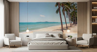 Coastal Palm Serenity wallpaper mural of beach and palms above a gray bed framed by two armchairs in a bedroom