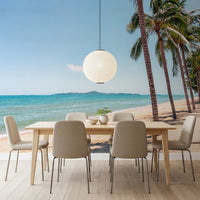 Coastal Palm Serenity wallpaper mural of beach and palms in a dining room with a wood table and round paper lantern