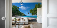 Beach scene with lush, green trees overhanging the sand.

