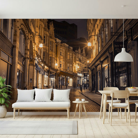 Cobblestone Street Nights wallpaper mural in a dining area with a white bench and light wood table