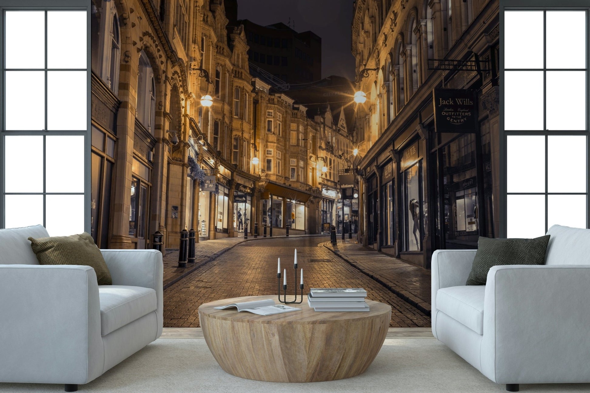Cobblestone Street Nights wallpaper mural behind two white armchairs and a round wood table in a living room