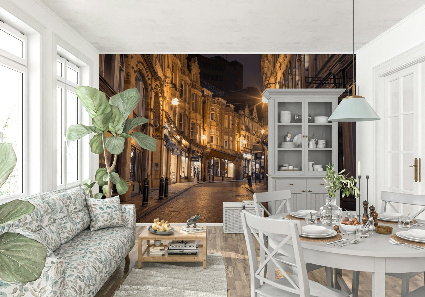 Cobblestone Street Nights wallpaper mural over a floral sofa and white dining set in an open-plan room