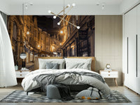 Cobblestone Street Nights wallpaper mural in a modern bedroom with a brass chandelier and geometric rug
