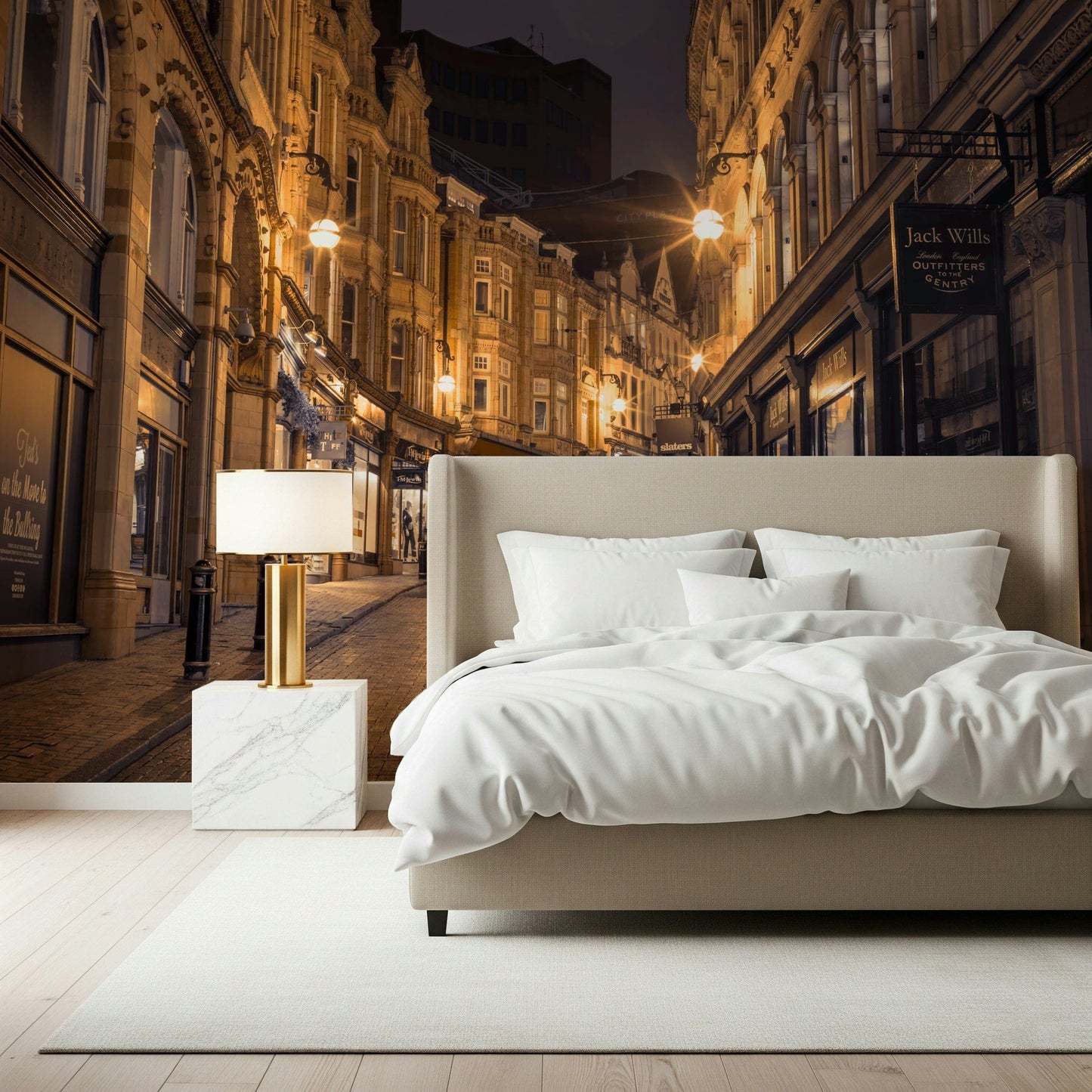 Cobblestone Street Nights wallpaper mural behind a beige bed with a gold lamp on a marble nightstand
