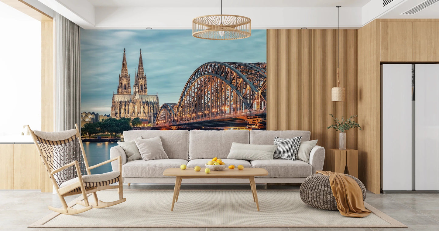 Cologne at Dusk wallpaper mural of the Rhine bridge and cathedral behind a grey sofa and rocking chair in a living room