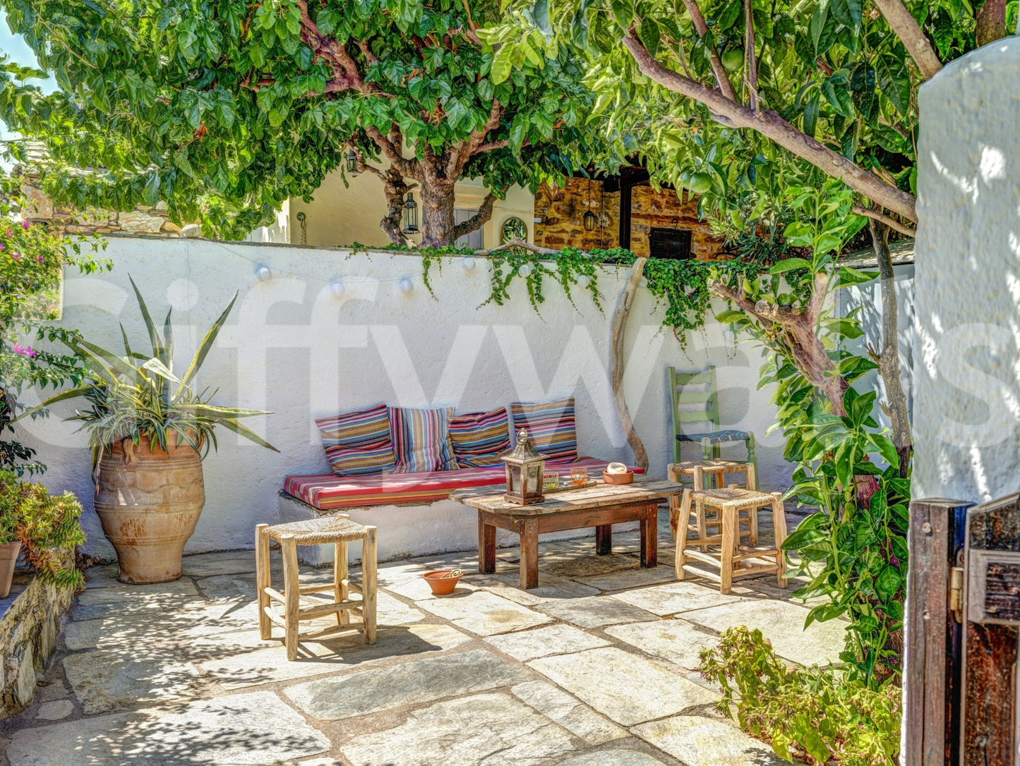Colorful Backyard Patio Wall Mural featuring bright textiles and stone floor.