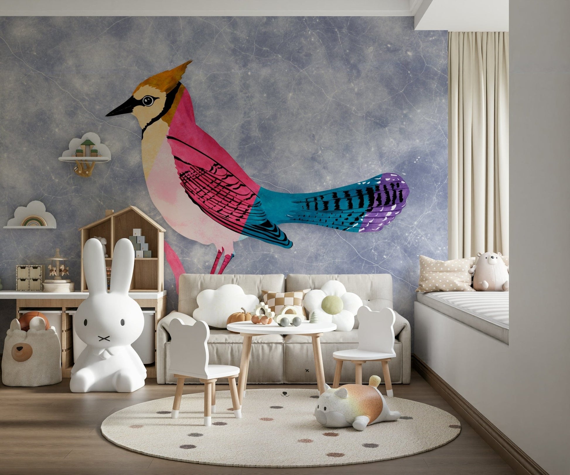 Colorful Jay wall mural in pink and blue behind a beige sofa and kids table in a playroom