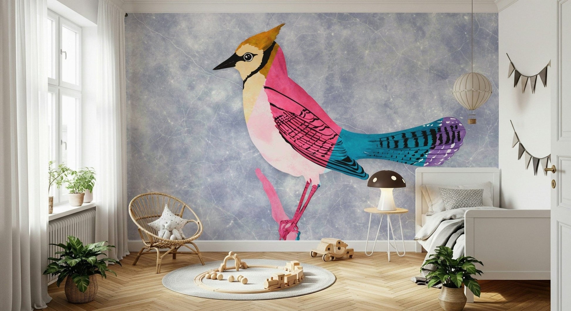 Colorful Jay wall mural, a pink and turquoise bird on blue behind a rattan chair and crib in a nursery