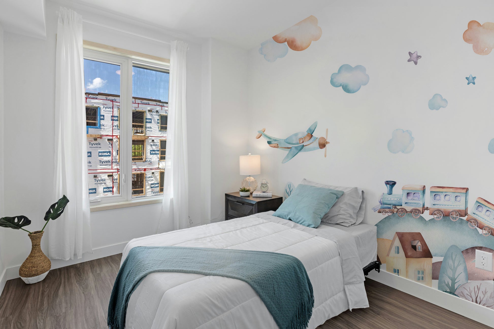 Watercolor Fun Village kids room wallpaper mural styled as a feature wall behind a dining table and chairs