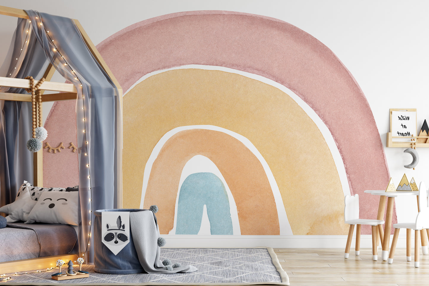 Watercolor Rainbow Colorful wallpaper mural in pink and yellow behind a canopy house bed with fairy lights