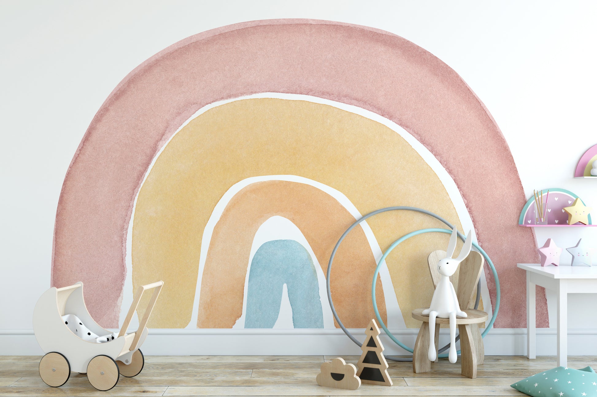 Watercolor Rainbow Colorful wallpaper mural in pink and yellow behind a white toy pram and bunny stool in a playroom